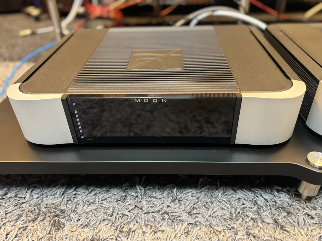 Front view of the MOON Compass 461 power amplifier with silver side panels and an illuminated status indicator.